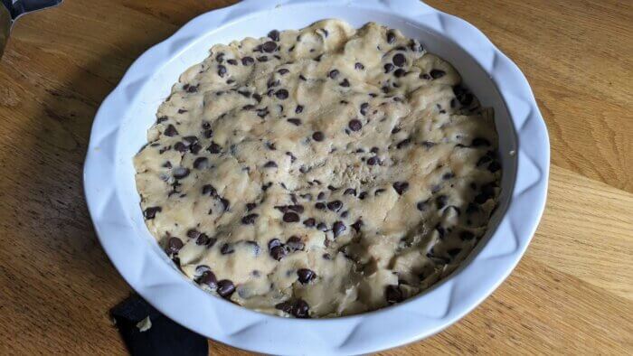 raw sourdough chocolate chip cookie dough batter pressed in a pie plate