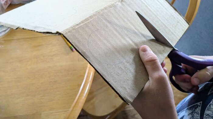 a boy cutting cardboard