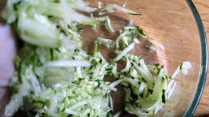 shredded cucumber being rung out