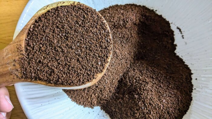 woman measuring out ground coffee