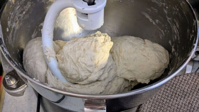 sourdough starter mixed with bread dough ingredients in a kitchen aid mixer