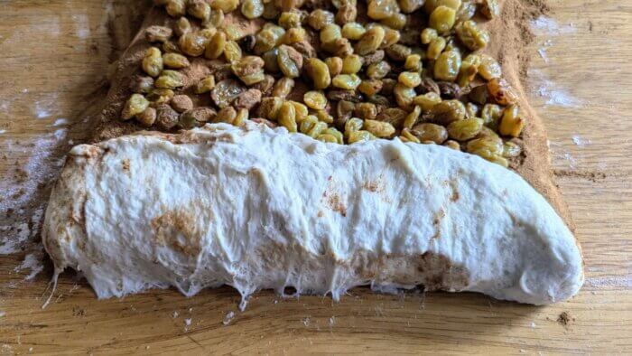 cinnamon raisin bread dough being rolled