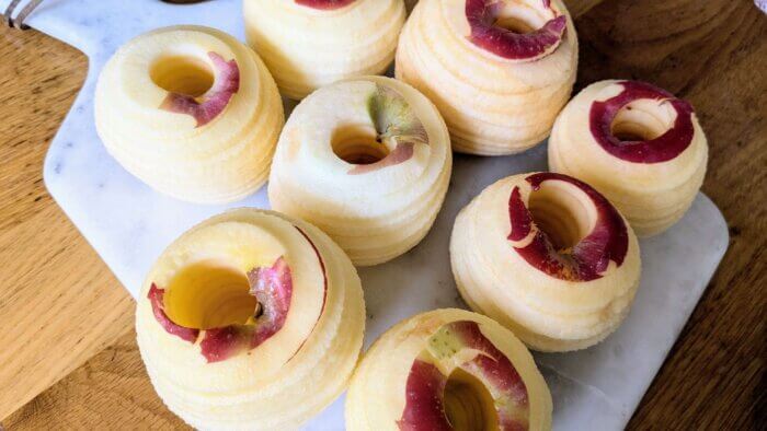 peeled, cored apples on a cutting board