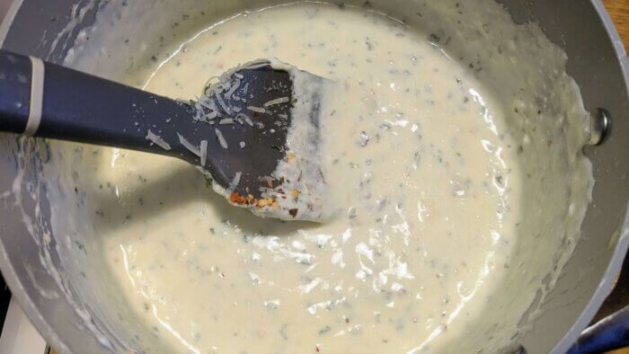 garlic Parmesan cream sauce being stirred