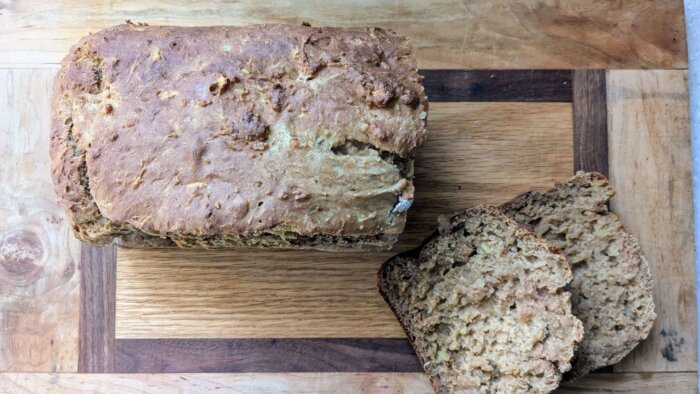 baked sweet potato bread on a cutting board with two slices next to it