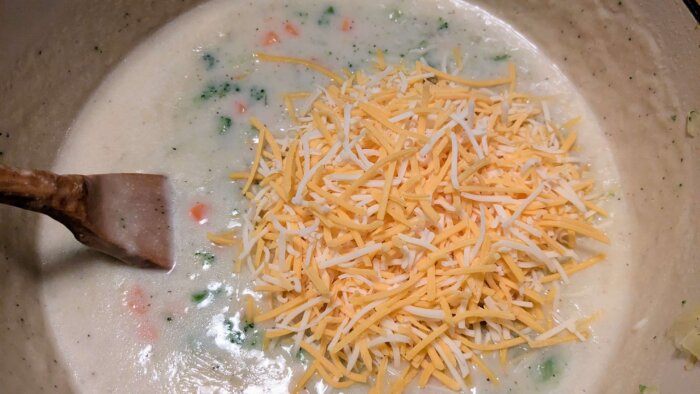 gluten-free broccoli cheddar soup with the cheddar cheese being mixed in