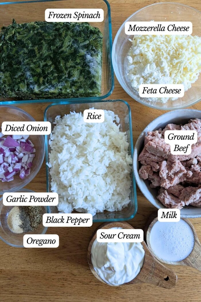 spinach and feta casserole ingredients labeled in seperate bowls on a counter 