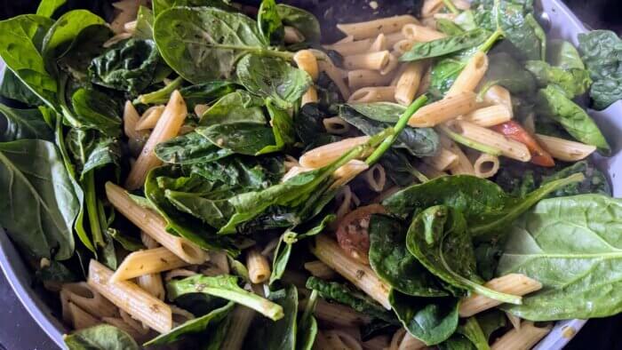 raw spinach in a pesto and tomato dish