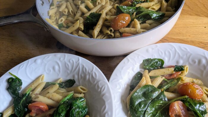 Pesto and Tomato Pasta in a skillet and in two bowls 