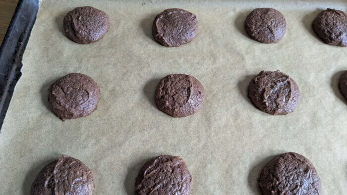 baked sourdough Brownie cookies on a parchment paper lined baking sheet
