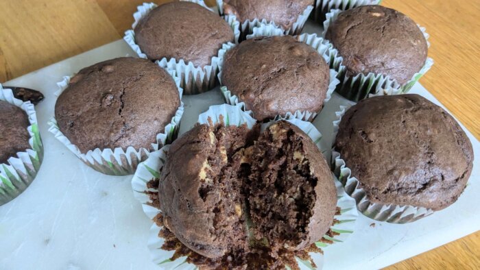 Peanut Butter Cup Sourdough Muffins on a marble cutting board with one muffin cut in half