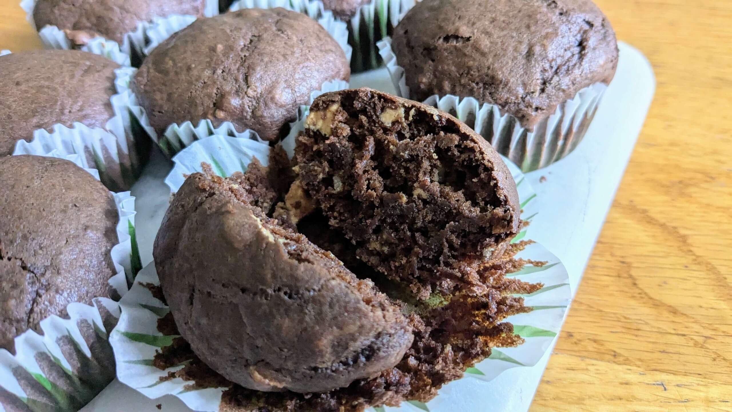 Peanut Butter Cup Sourdough Muffins on a marble cutting board with one muffin cut in half