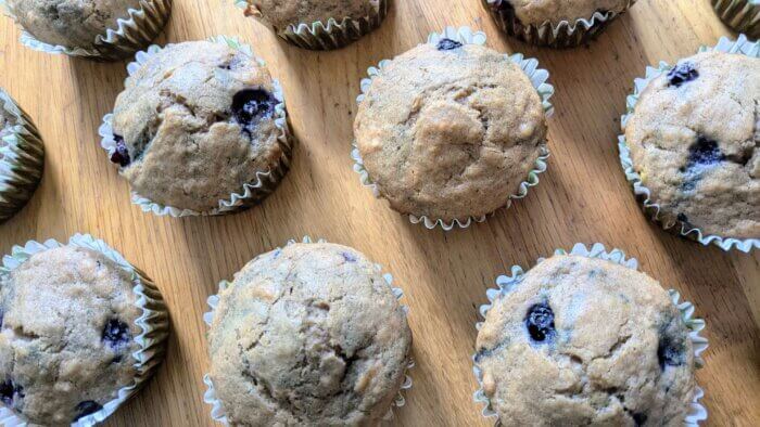 baked sourdough discard Blueberry muffins laid out on a wooden countertop