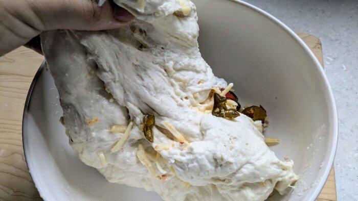 woman stretching and folding cowboy candy sourdough boulle 