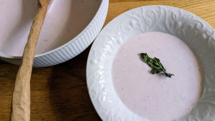 two bowls of chilled strawberry bisque garnished with mint