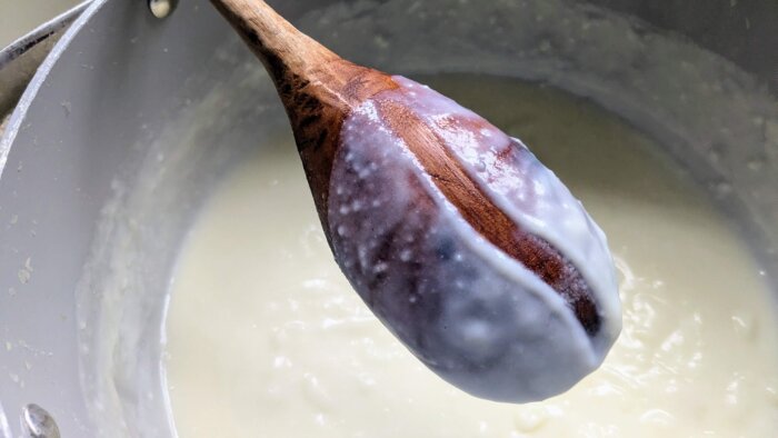 a wooden spoon with a line running through the thickend liquid on the back. 